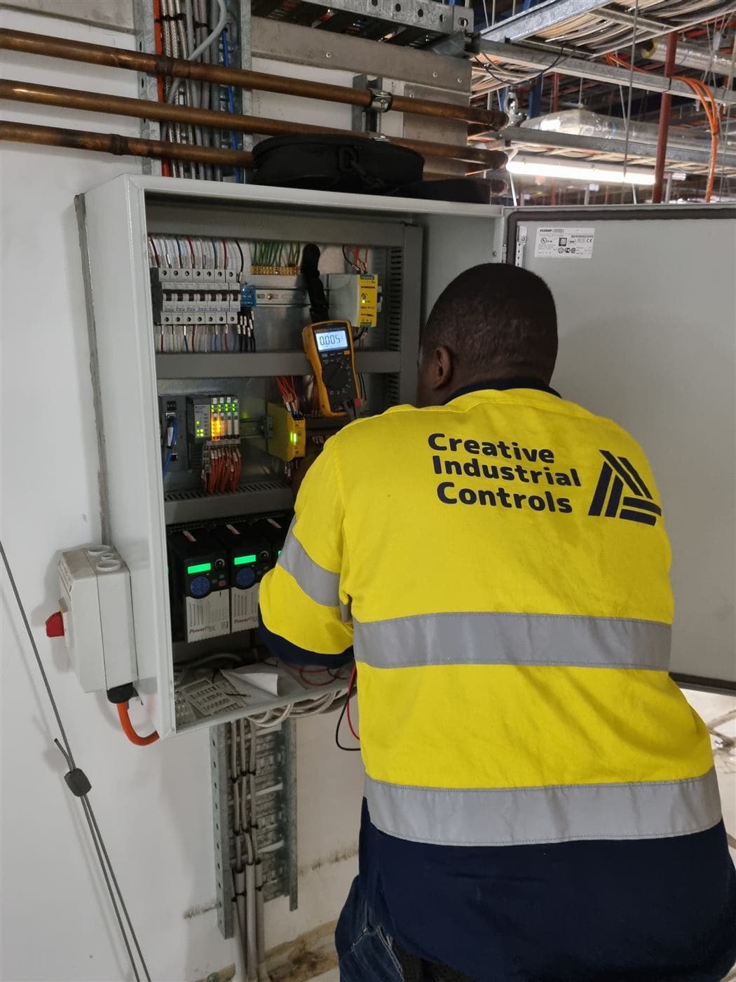 CIC technician working inside an industrial control panel