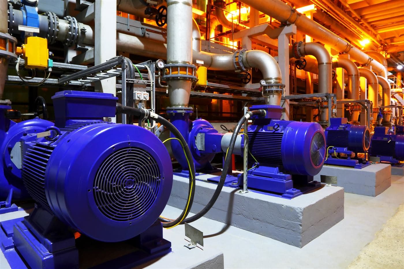 Industrial pump motors and pipework in a plant room